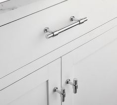 a white cabinet with chrome handles and knobs