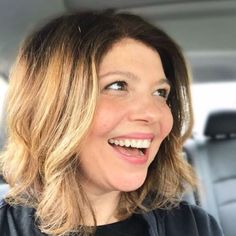 a woman smiling in the back seat of a car