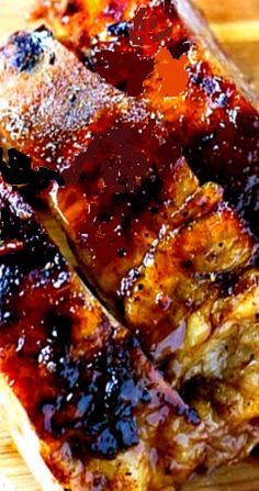 some meat is sitting on top of a cutting board with ketchup and mustard