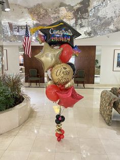 balloons in the shape of stars and graduation caps are on display at an airport lobby