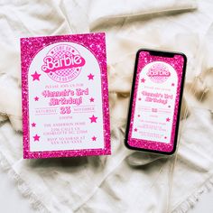 a pink and white birthday party card next to an iphone on top of a blanket