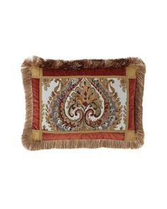 an embroidered pillow with fringe trim on the edges and a paisley design in red, gold and white