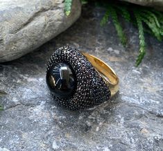 "14k Yellow Gold Sterling Silver Black Onyx Orb Pave Black Spinel Nest Ring Size 6.5 up for offer is a stunning 14k yellow gold over solid sterling silver black onyx orb set in a nest of pave black spinel ring. This ring is marked \"925\". Measurements Ring Size: 6.5 Band Width: 4mm Black Onyx Orb: 13mm Black Spinel: 1.3mm Weight: 9.5 g Materials -14k Yellow Gold -Sterling Silver -Black Onyx -Black Spinel Condition: New; Please look closely at the pictures provided as they are an extension of th Black Sapphire Ring With Gemstone In Luxury Style, Black Sapphire Ring In Luxury Style, Black Sapphire Luxury Ring, Luxury Black Onyx Diamond Ring, Luxury Black Stone Jewelry, Anniversary Black Cabochon Rings, Fine Jewelry Black Onyx Diamond Ring, Black Onyx Crystal Ring With Gemstone, Black Rings With Round Gemstone