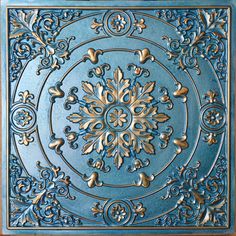 an intricately designed ceiling tile with gold and blue accents on the center, is shown