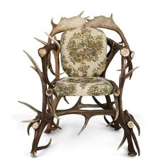 a chair made out of antlers and fabric with an intricate design on the back