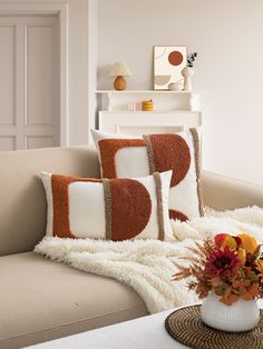 a living room filled with furniture and pillows on top of a white table next to a fire place