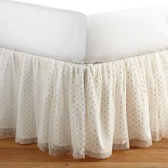 the bed skirt has been made with white polka dots