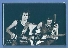 two men are playing guitars together in black and white photo with blue border around them