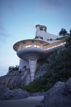 an unusual house built on the side of a cliff with trees growing out of it