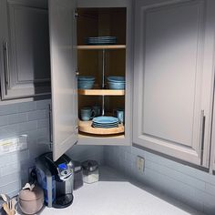 an open cabinet in the corner of a kitchen