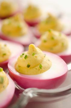 deviled eggs with chives and green onions on a plate