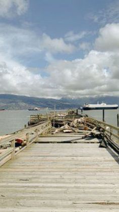 there is a boat docked at the end of this pier with no people on it