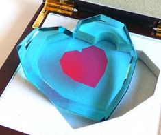 an origami heart in a box on a table