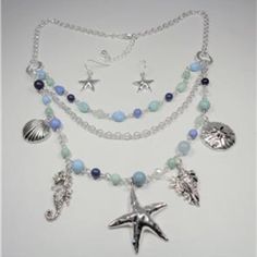 This Beautiful Rhodium Nautical Starfish Seashell Aqua And Blue Beads Sea Life Layered Necklace And Earrings Set Features Aqua, Blue And Rhodium Beads With The Rhodium Sea Horse, Seashells, Sand Dollar And Starfish Charms As Well As Aqua And Blue Beads And Bluish Pearls. The Silver Tone Necklace Is 20 Inches Long With A 2 Inch Extender To 22 Inches And Has A Lobster Claw Clasp For A Secure Fit On Your Neck. The Starfish Pendant Measures 1 1/2 Inches High And 1 1/2 Inches Wide. Cn 5-0032 Adjustable Blue Starfish Jewelry, Adjustable Blue Jewelry With Starfish Charm, Ocean-inspired Colorful Beads Jewelry, Ocean-inspired Blue Jewelry With Colorful Beads, Ocean-inspired Beaded Jewelry, Bohemian Starfish Jewelry With Lobster Clasp, Bohemian Blue Jewelry With Starfish Charm, Bohemian Blue Starfish Charm Jewelry, Blue Multi-strand Jewelry With Dangling Beads