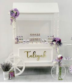 there is a white cart with purple flowers on it and the word tallya written in gold