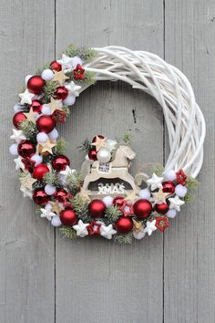 a white wreath with red and white ornaments