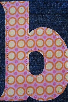 the letter b is made out of fabric and has an orange dot pattern on it