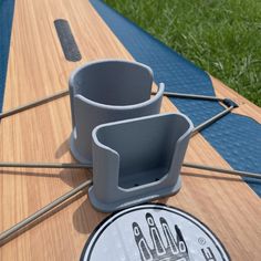 a close up of a surfboard with two cups on it and some sticks sticking out of the top