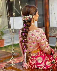 a woman sitting on a swing with flowers in her hair and wearing a pink dress