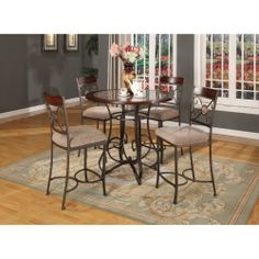 a dining room table with four chairs and a rug