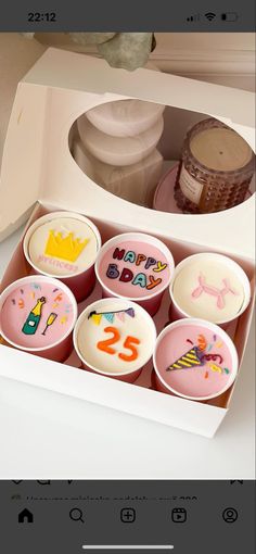 the cupcakes in the box are decorated with candles and numbers for birthday celebrations