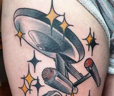 an old school style tattoo on the thigh shows a flying saucer and two pepper shakers