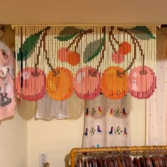 there are many pieces of bead work hanging on the wall in front of the window