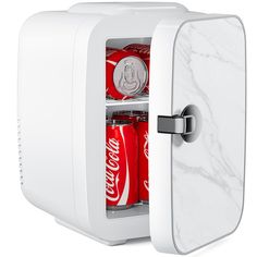 a white mini fridge with soda cans in it's door and the interior is marbled