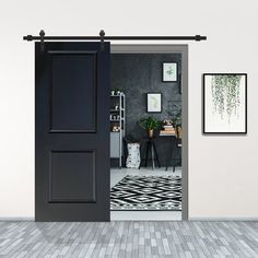 an open door leading to a living room with black and white decor on the walls