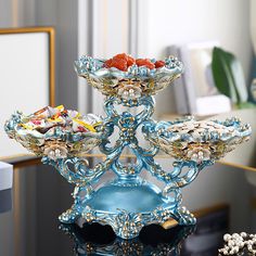 an ornate blue glass stand on top of a table with candy and candies in it