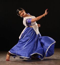 a woman in a blue dress is dancing