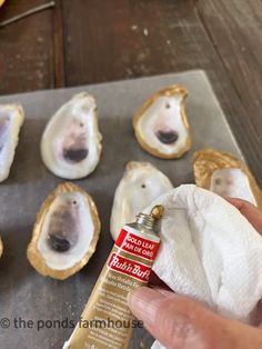 a person is holding an empty bottle in front of some oysters