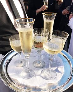 three glasses of champagne sitting on top of a silver tray