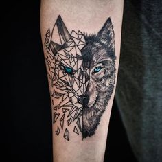 a black and grey tattoo with two wolfs on it's arm, one has blue eyes