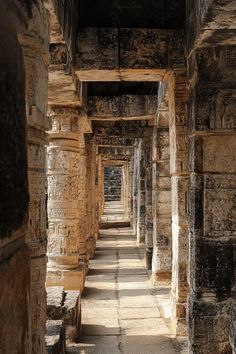 the inside of an ancient building with stone pillars and columns on either side of it