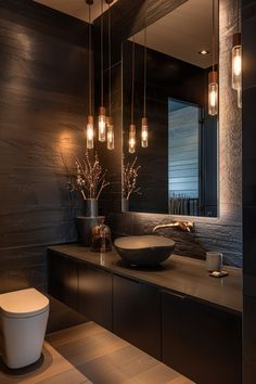 a bathroom with black walls and lights hanging from the ceiling