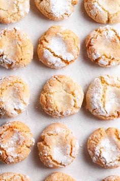 freshly baked powdered sugar cookies lined up on a baking sheet, ready to be eaten