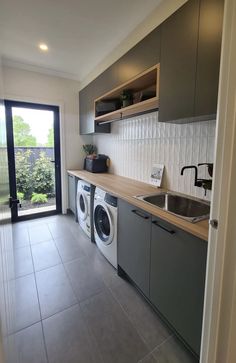 a washer and dryer in a small room with sliding glass doors to the outside