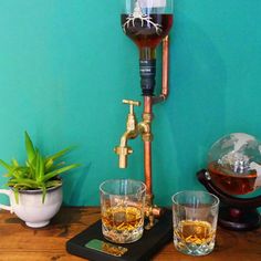 an old fashioned coffee maker with two glasses