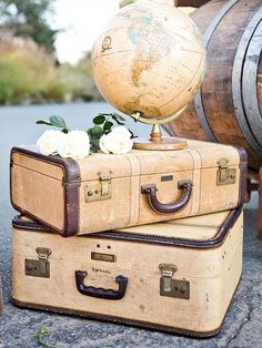 two suitcases are stacked on top of each other with a globe in the background