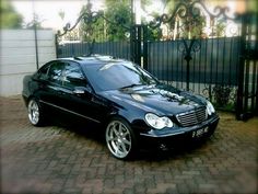 a black car parked in front of a gate