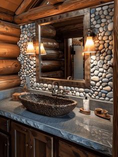 a stone sink in front of a large mirror and wooden cabinets with lights on it