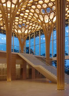 the inside of a large building with many windows and wooden columns on each side of it