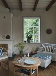 a living room filled with furniture and a fire place in front of a large window