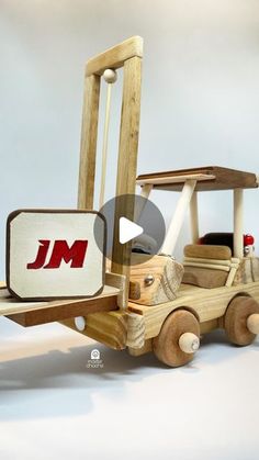 a wooden toy truck that is made to look like a construction vehicle with the word j m on it