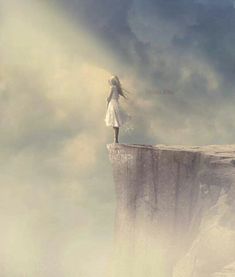 a woman standing on the edge of a cliff