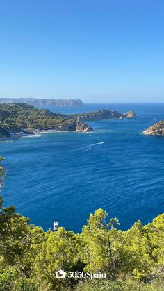 the blue water is surrounded by trees and mountains in the distance, with boats on the water