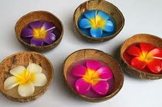 four wooden bowls filled with colorful flowers on top of a white tablecloth covered floor