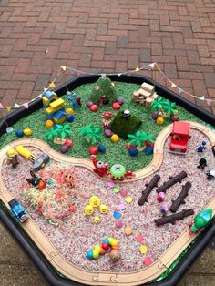 a toy train set is sitting on top of a play table with lots of toys