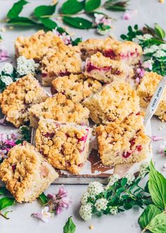 several pieces of crumbly dessert sitting on top of a table with flowers and leaves